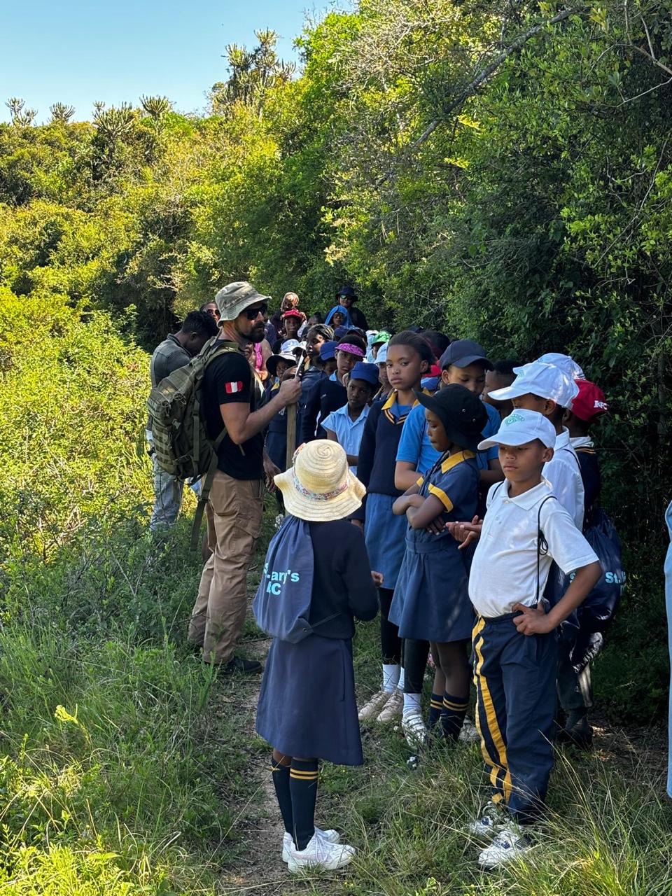 Schoolchildren gathered around a VWRA guide on the trail